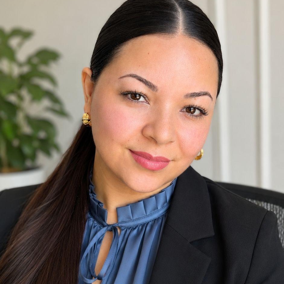 Gissel “Gigi” Mejia, USCIS Practice Manager, wearing a blue blouse and black blazer